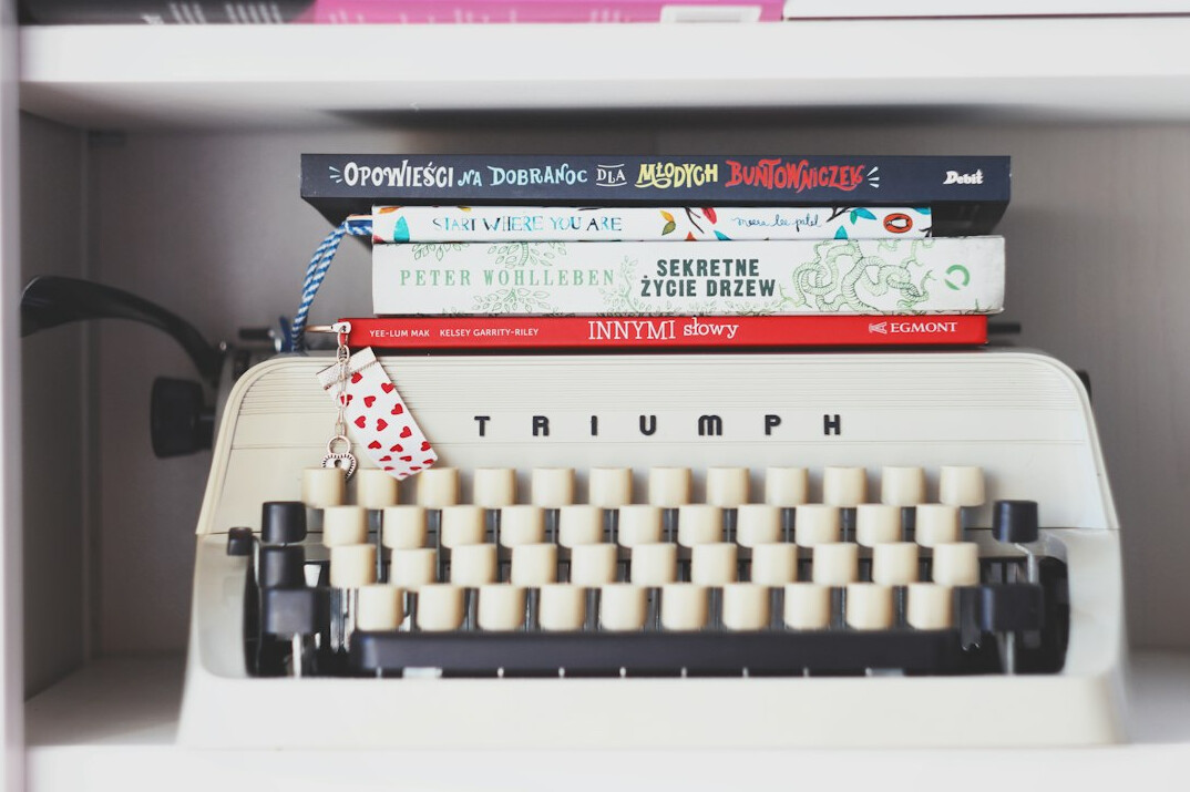 Stack of old books with a vintage typewriter